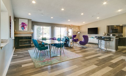 A modern living room with a fireplace and a dining table set up.